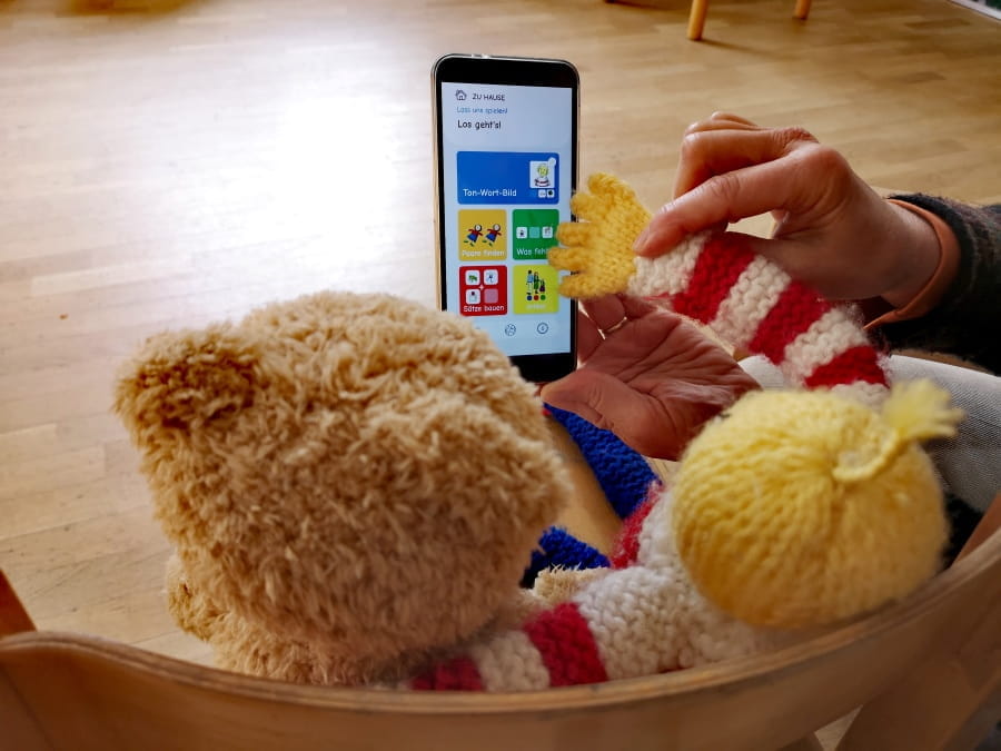 A teddy bear and a puppet using the Kikus mobile app