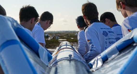 Students carrying rocket